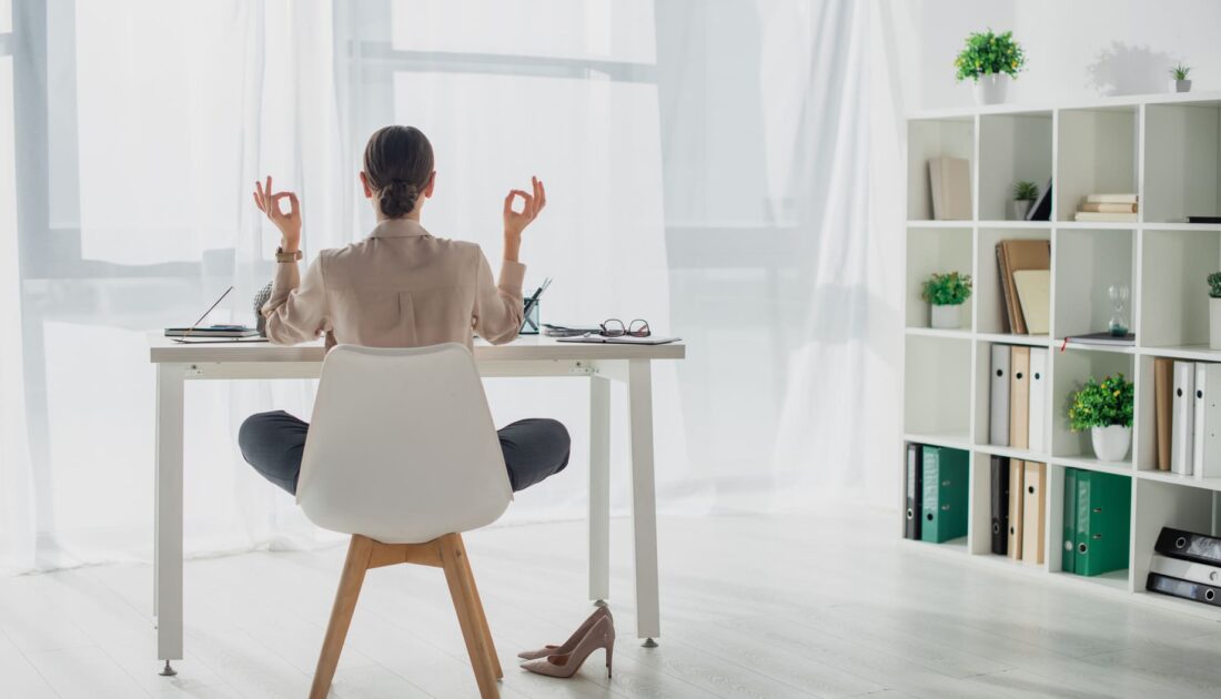 Femme étant relaxée en travaillant à son bureau