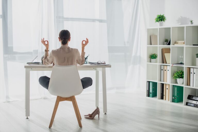 Femme étant relaxée en travaillant à son bureau